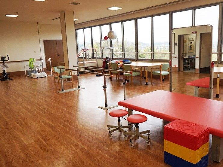 平行棒やリハビリマシンを設置したリハビリスペースには作業用のテーブルやベッドも設置されている。