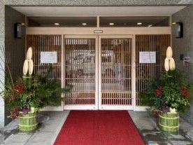 門松が両サイドに設置されている自動ドアが付いたエントランスには赤いマットも敷かれている。