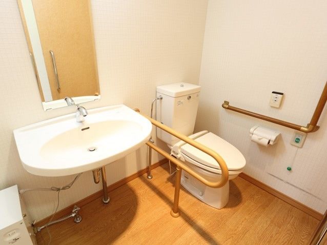 洗面台がついたトイレの様子。両側に手すりがあり緊急コールも用意されている