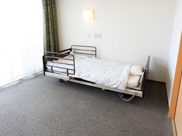 介護仕様のベッドが置いてある小さな部屋の様子。施設内の居室の写真
