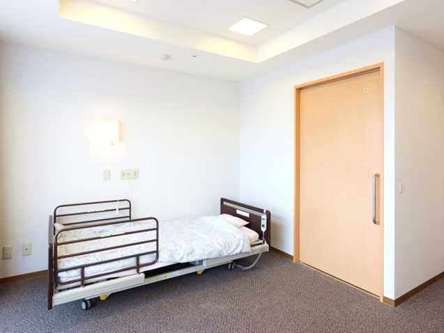 介護用ベッドが置いてある施設内の居室の様子。左側に収納がついている
