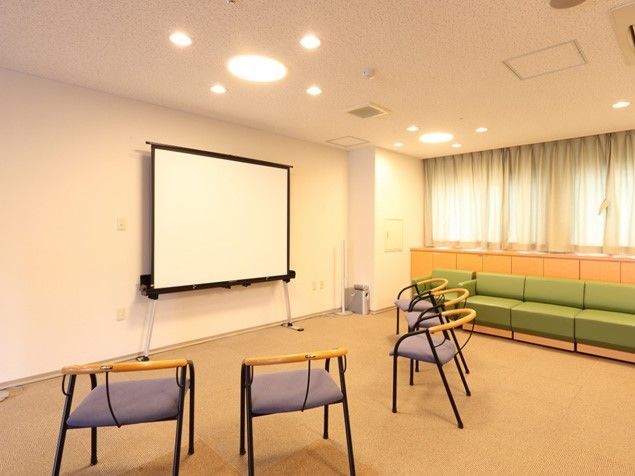 緑色のソファと3脚の椅子が並べられている施設内のシアタールーム