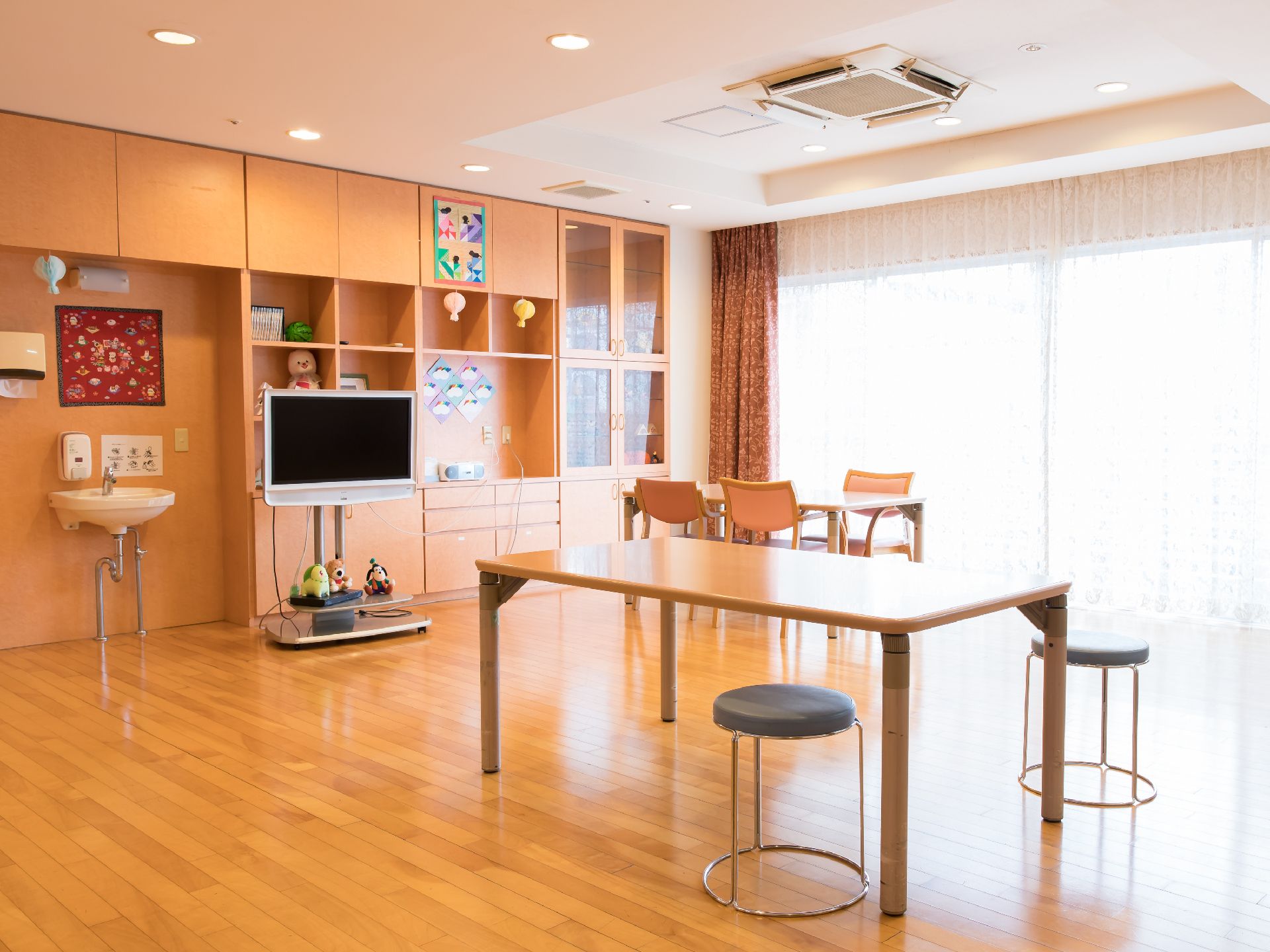 テーブルやイス、テレビなどが設置された、日当たりの良い部屋