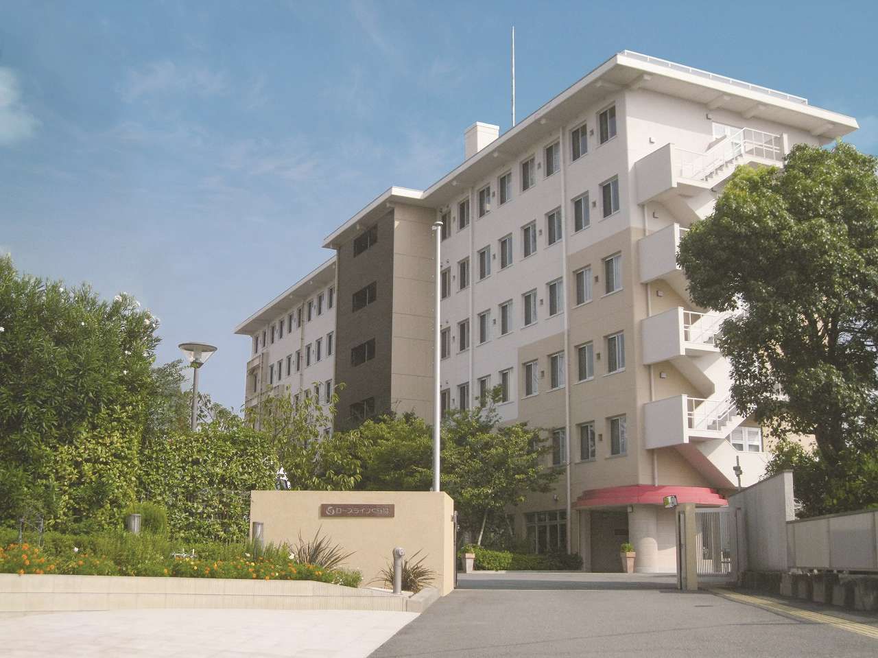 なにかを見て笑顔で手をたたいている高齢女性とスタッフの様子。施設での一場面の写真