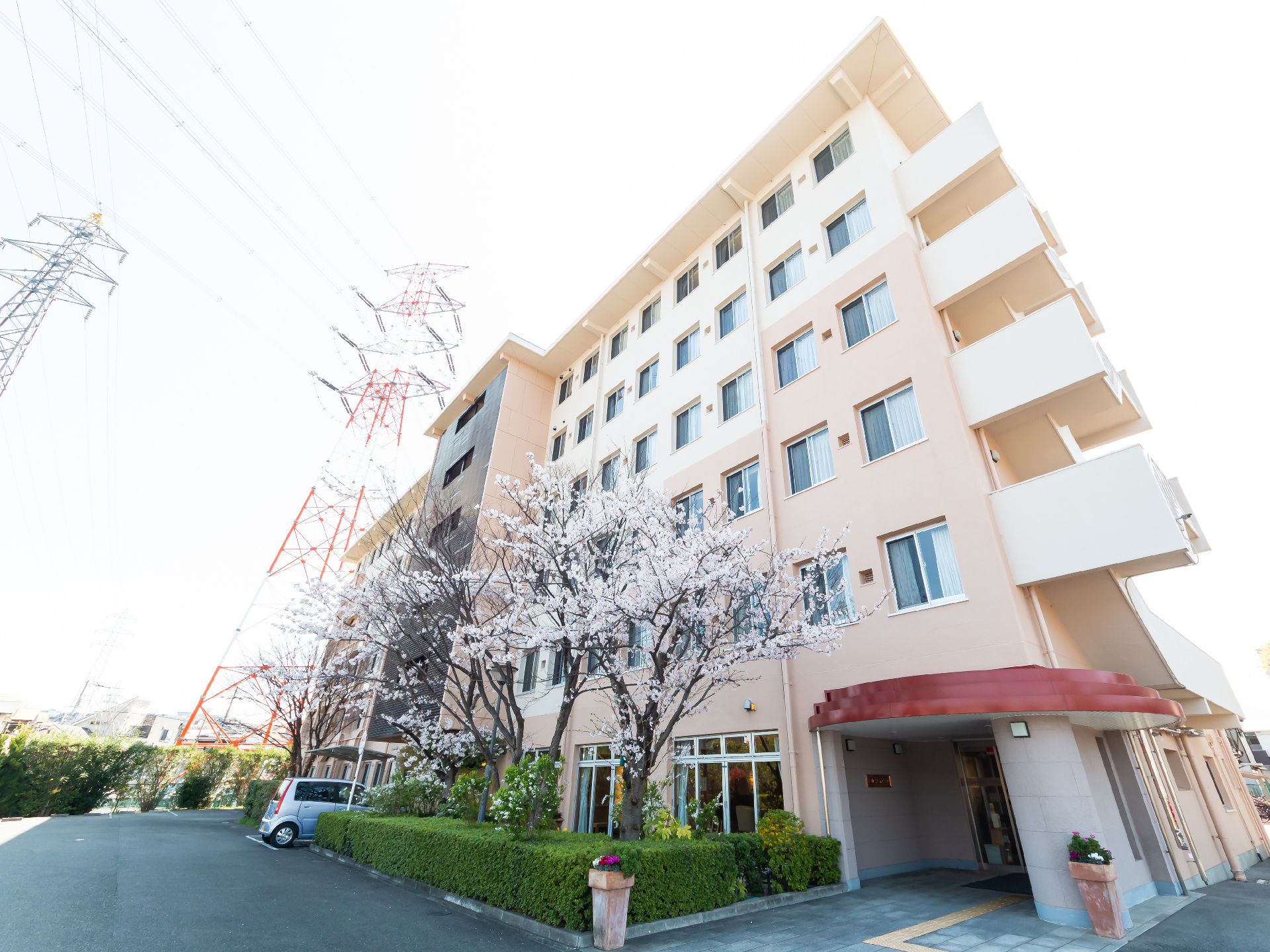 高齢者施設の外観と花の咲く木々