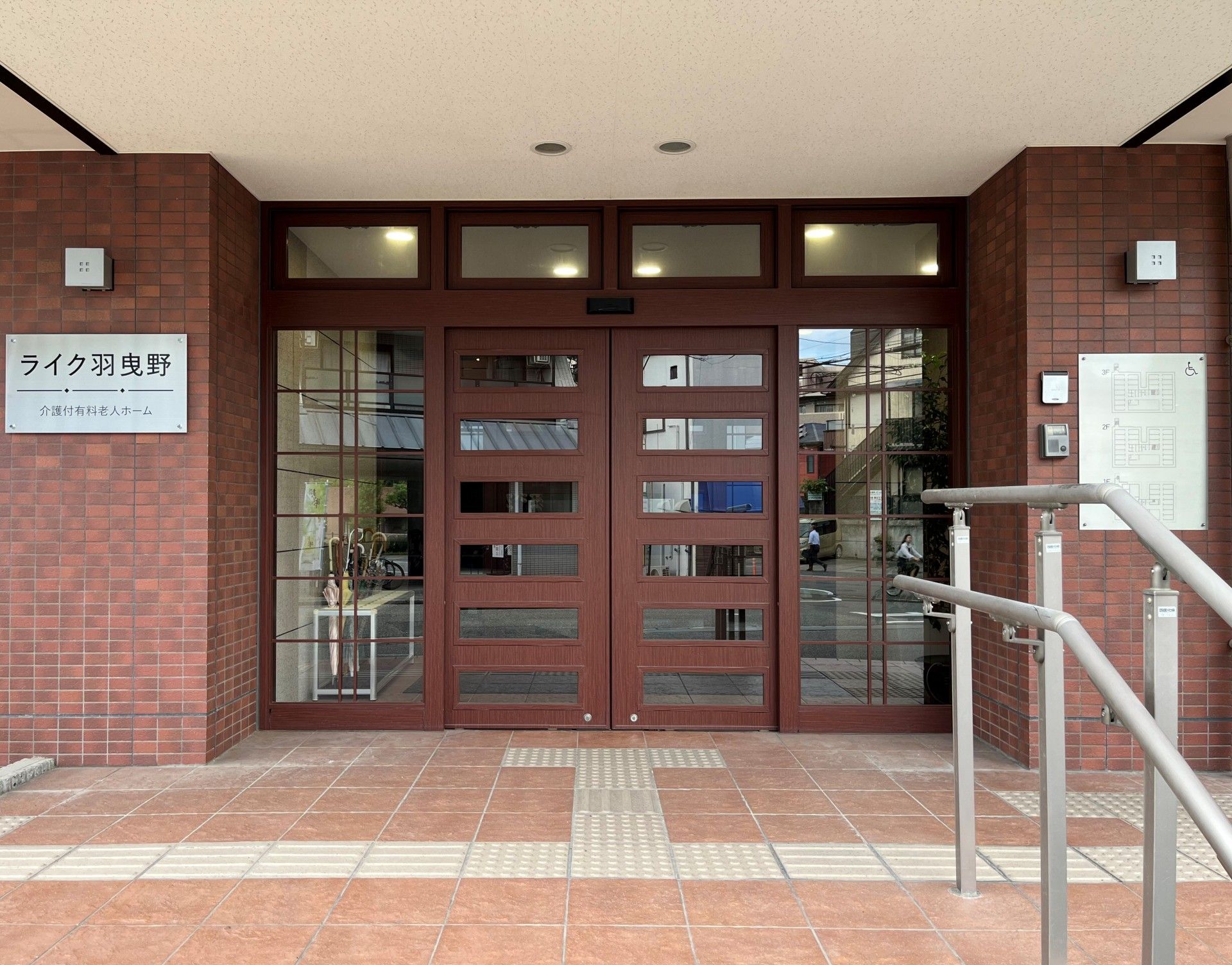 患者のケアをする看護師・介護士とベッドに横たわる高齢者。介護している写真