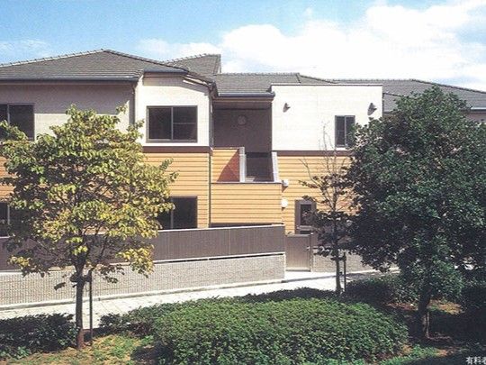 1階が茶色、2階と3階が白い外壁で三角屋根の2階建て建築物