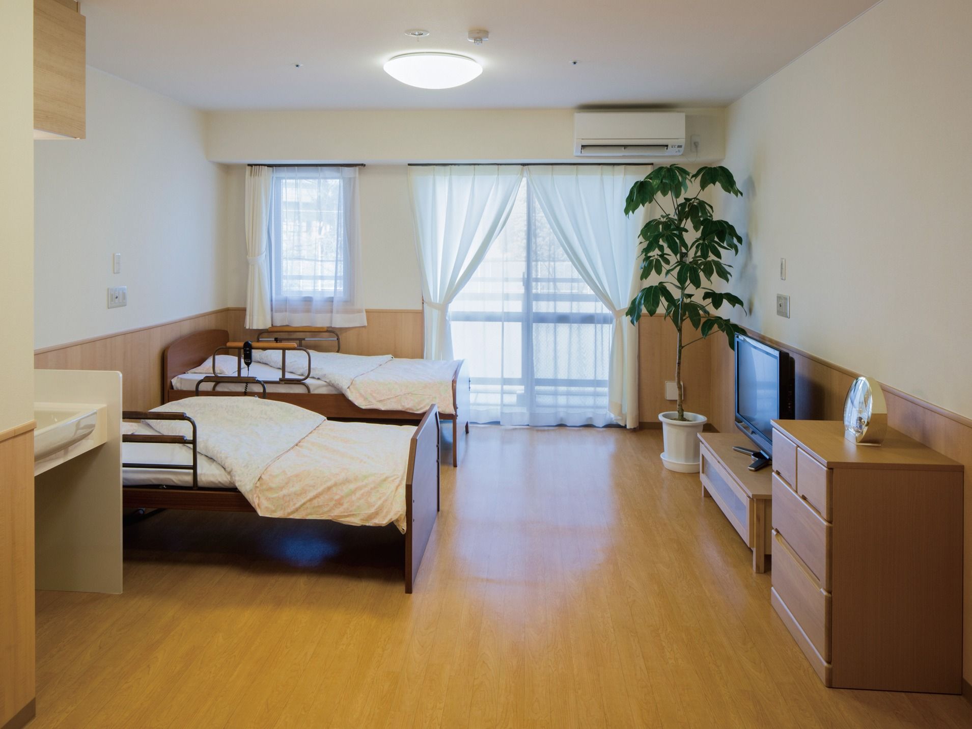 ２つのベッドや洗面台が設置された、夫婦入居が可能な居室
