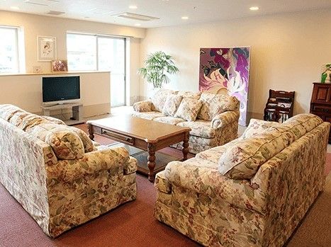 談話コーナーには絵画や観葉植物が置かれ、どっしりとした応接セットがテレビを囲むようにしてある。