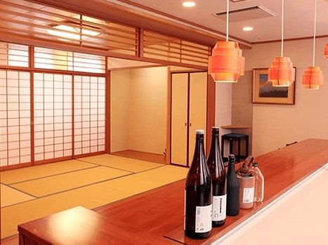 本格的な畳の部屋の手前には和風のカウンターがあり、一升瓶や酒樽が置かれている。