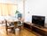 部屋には椅子やテーブル、テレビなどが設置されている。窓にはイエロー系の遮光カーテンが付けられている。