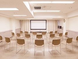 集会所にはたくさんの椅子が並べられ、前にはスクリーンが設置されている。