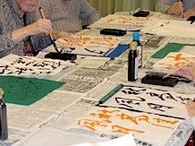 高齢者が書道をしている様子。レクリエーションのひとつを写した写真
