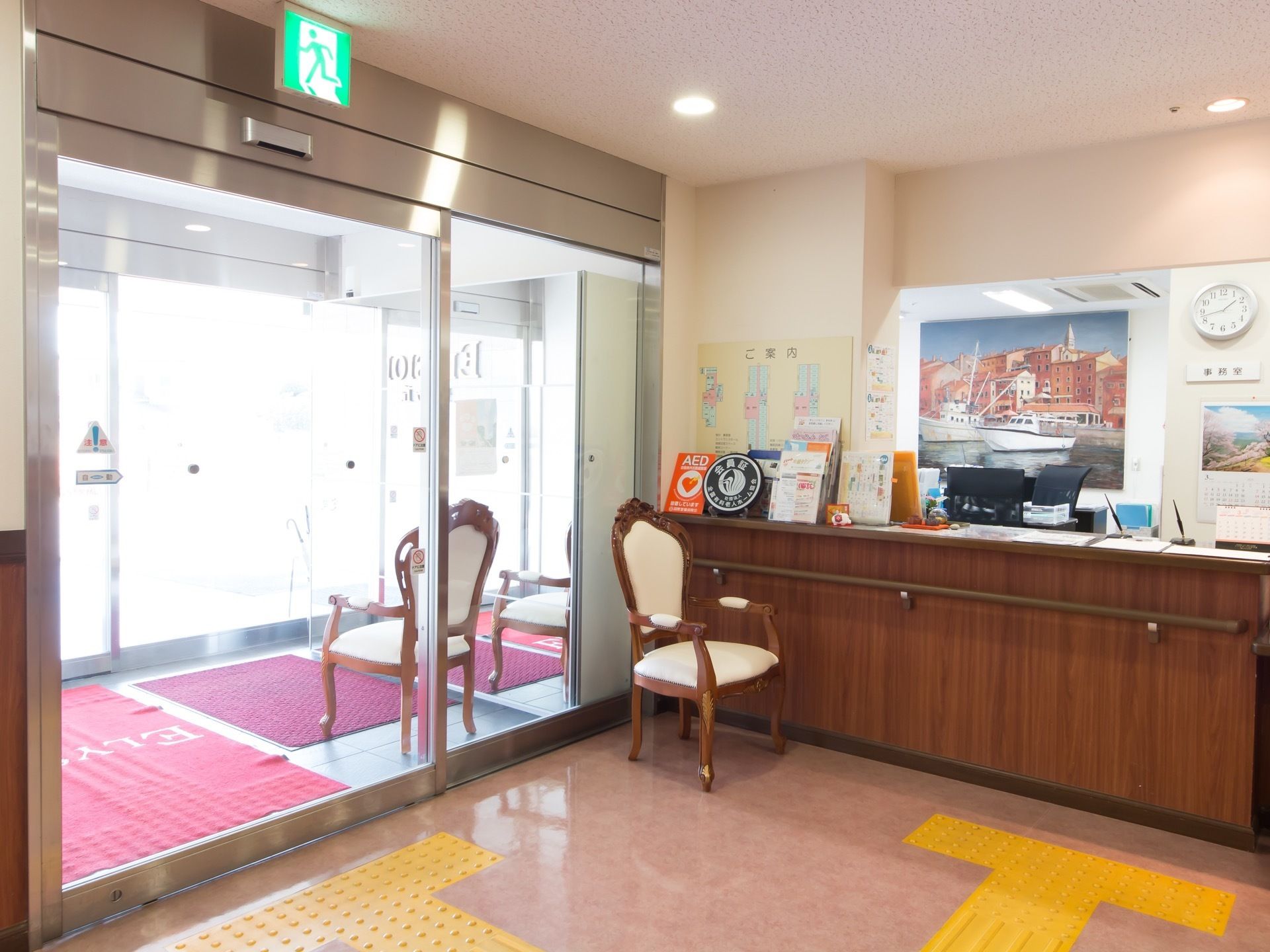 玄関の内側に風除スペースがあり、椅子が１脚置かれている。ロビーに入るとすぐに事務室があり、その手前にカウンターが設置されている。