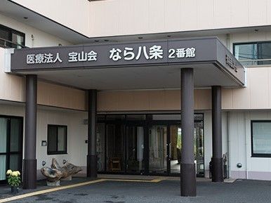 建物の玄関部分のアップ。正面の入り口はガラス扉となっており、玄関には大きな屋根が付いている。