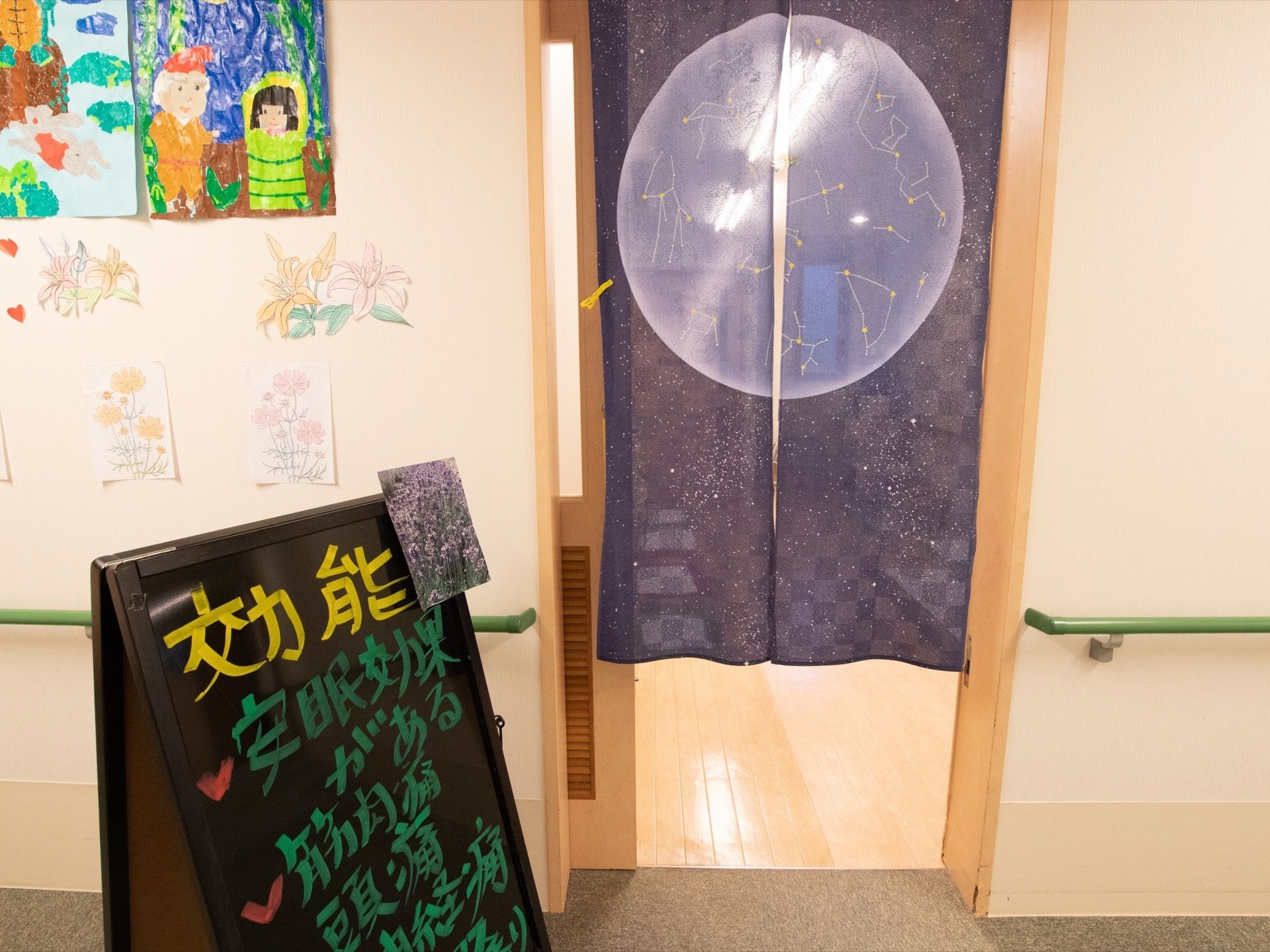 通路の壁にはかぐや姫やうさぎとかめのイラストが飾られている。横には星座模様の暖簾がかけられており、看板が立てかけられている。