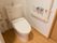 温水洗浄機能付きのトイレがある。フローリングで、壁にはＬ字型の手すりの他に、緊急用の通報装置も備え付けられている。