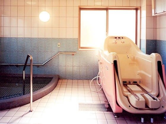 白とピンクの機械浴が設置された大浴場。大きな窓が付き日当たりがよく、左側には大きな浴槽も付いている。