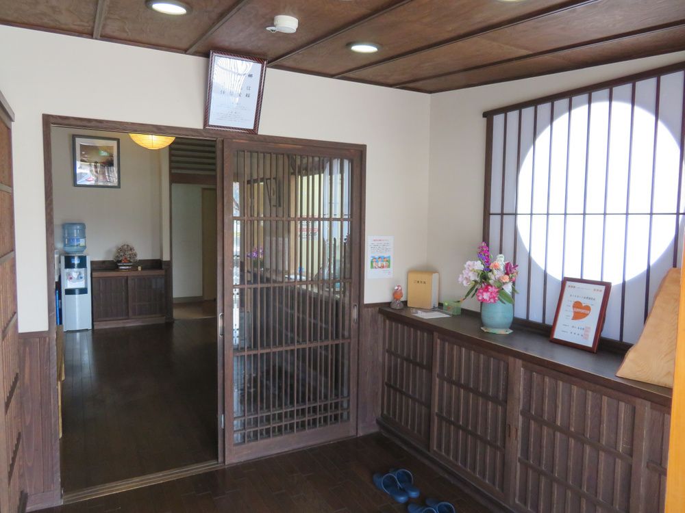 木製の靴箱の上には季節の花が飾られ、引き戸を開けて入るとウォーターサーバーがある。