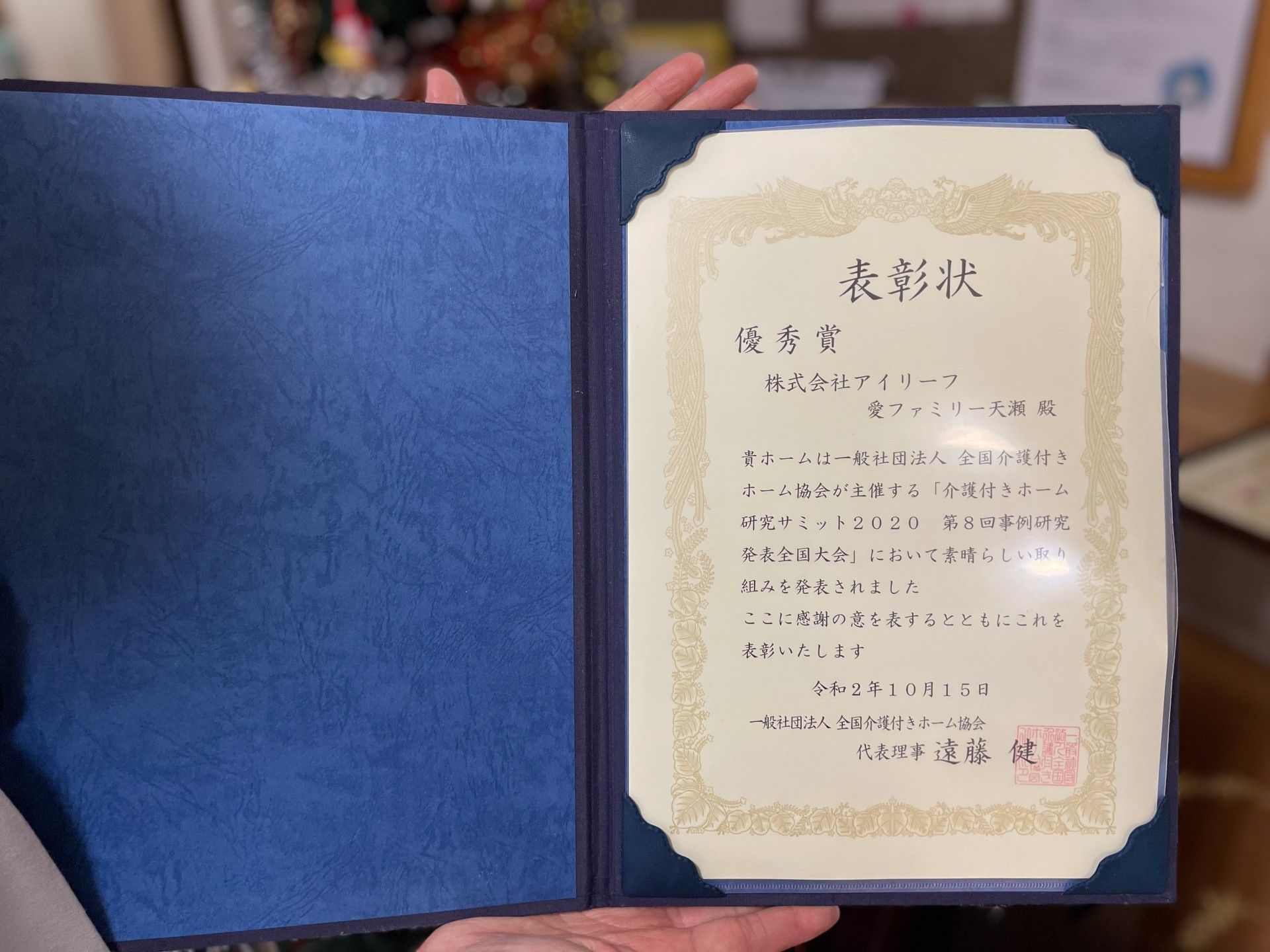 表彰状を持つ手元