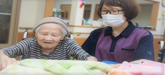 笑顔のおばあさんとスタッフ