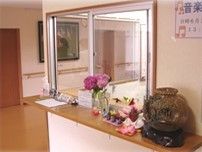 花が飾ってあるカウンターとその奥にあるスタッフステーション。施設内の一角の写真