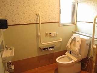 便座の右側にペーパーホルダー、洗浄機能の操作盤、緊急呼出しボタンが付いている。Ｌ字型の手すりも設置してある。安全面に配慮した設計である。