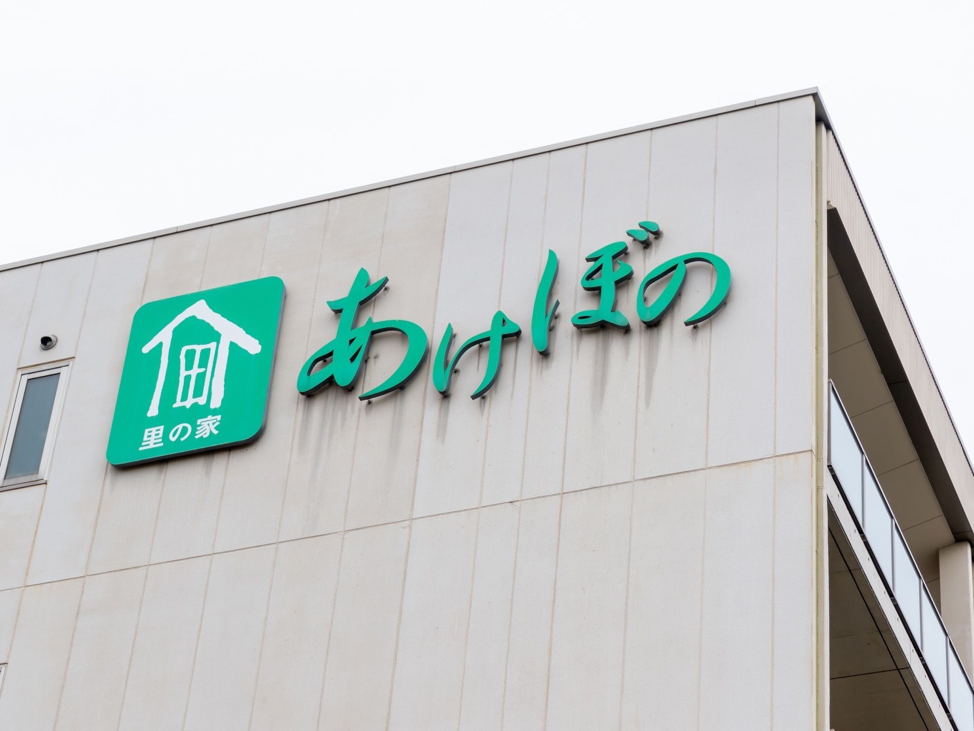 建物の外壁の色はベージュ系である。最上階の壁に緑色の行書体の切り文字で、施設名とロゴマークを表示している。