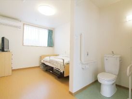 トイレが付いている居室の様子。奥のほうにベッド、窓、テレビ台などが見えている