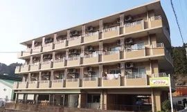 各フロアにベランダがあり、日当たりのいい場所に建っているブラウン系の外壁の4階建ての建物。