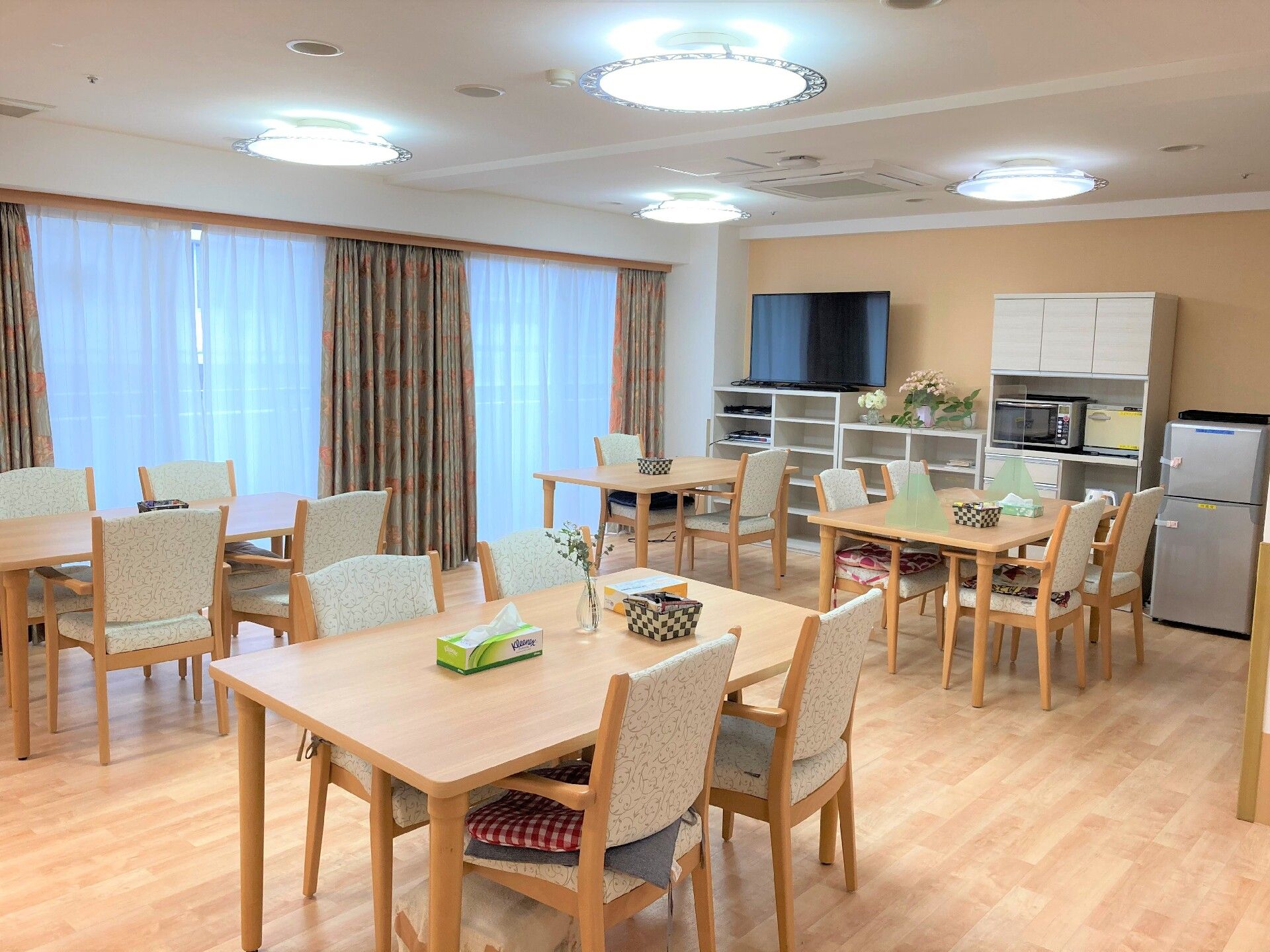 食堂にはテレビや食器戸棚、冷蔵庫も置かれている。流し台があり、キッチンのようになっている。掲示板にはお知らせが貼ってある。