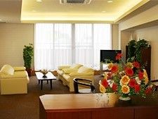 大きな窓のそばにはテレビやソファセットがあり、手前のテーブルの上にはフラワーアレンジメントが飾られている。
