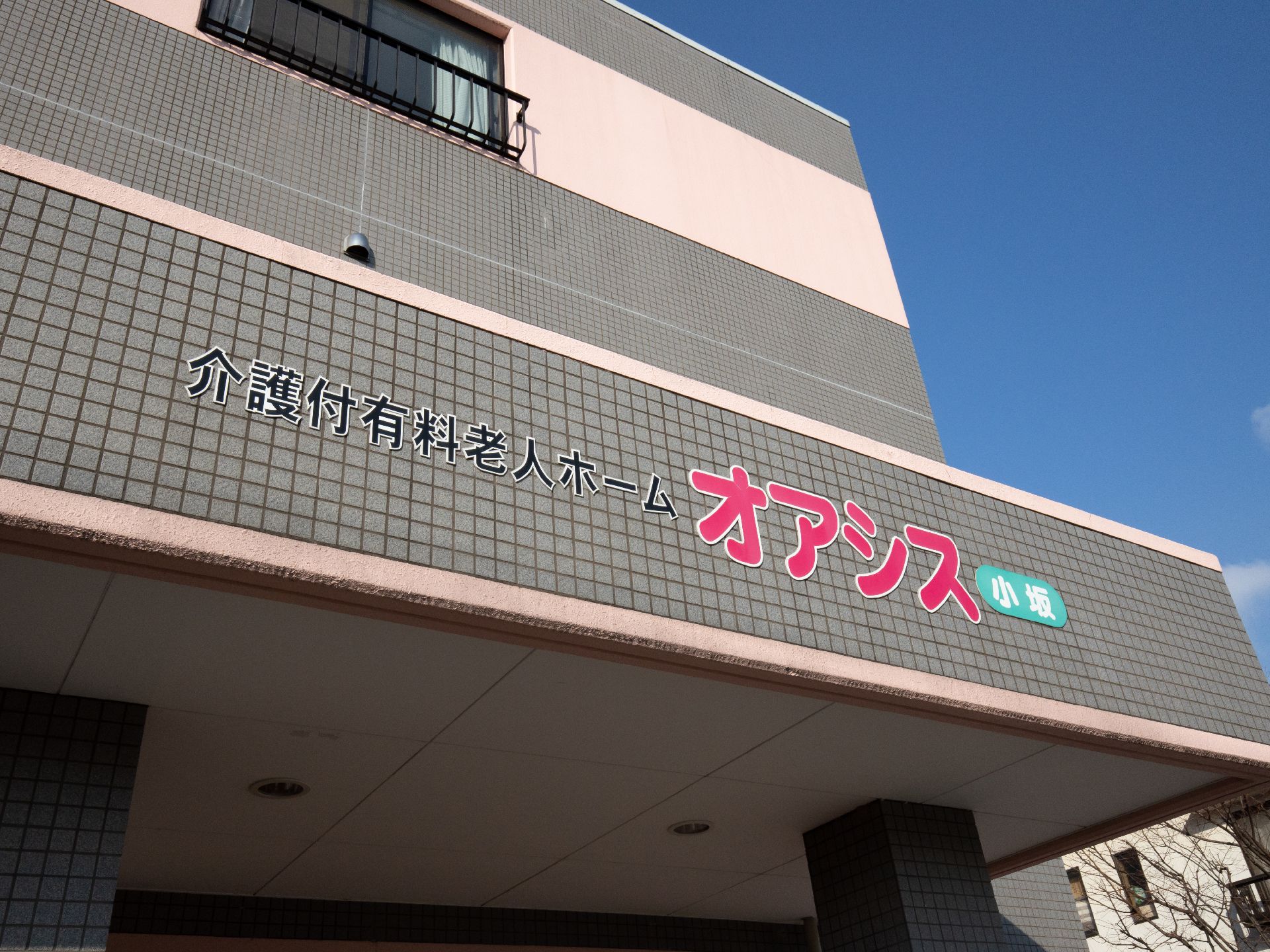 屋根には施設名が表示されている。グレーの壁に鮮やかなピンクの大きな文字で書かれており、遠くからでもよく見えるようになっている。