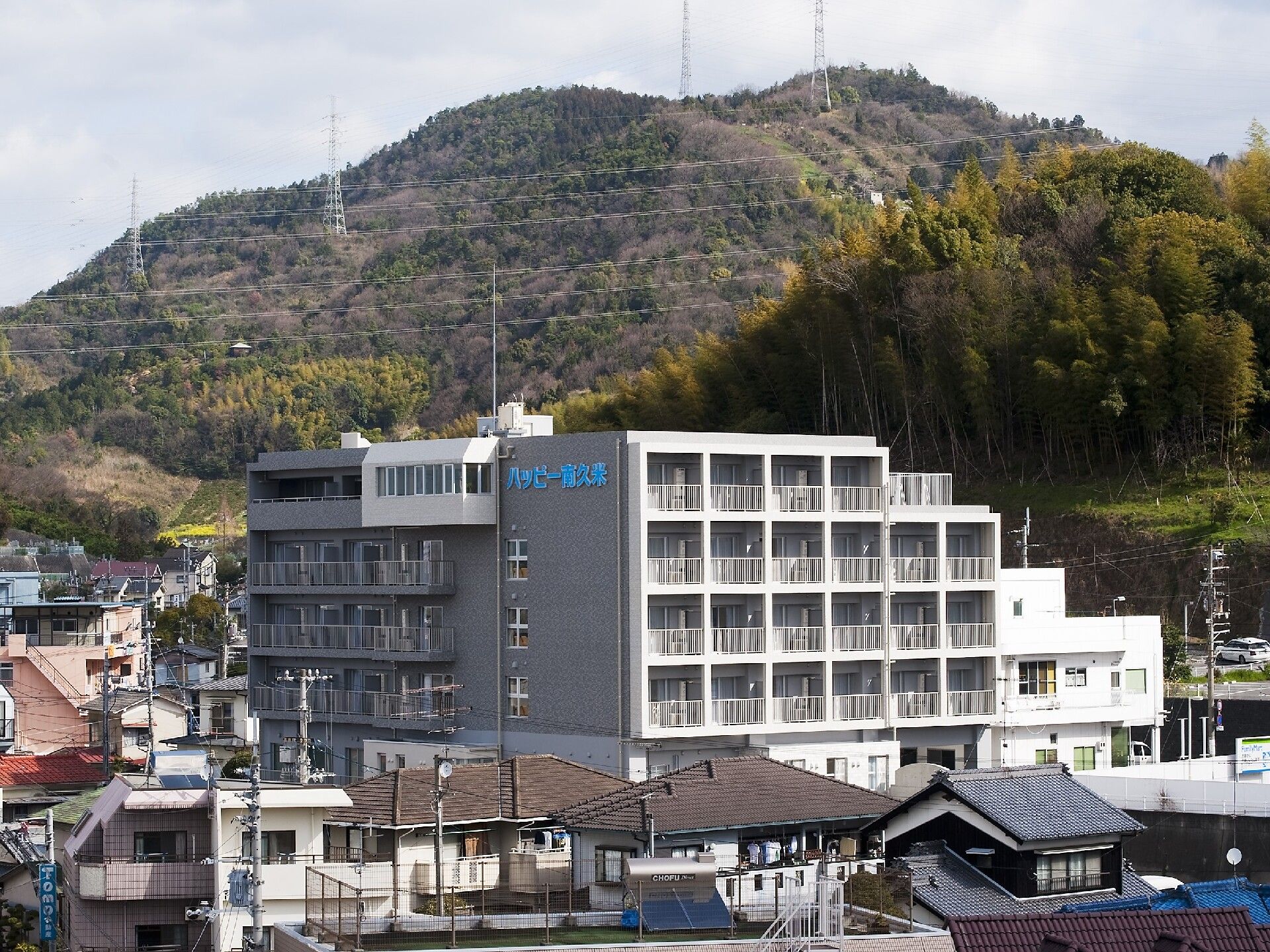 自然に囲まれた大きな建物の周りにはたくさんの民家があり、外壁にはホーム名が書かれている。