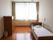 ベッドサイドには緊急通報装置が付いたフローリングの部屋には寝具付きのベッドやタンスなどがある。