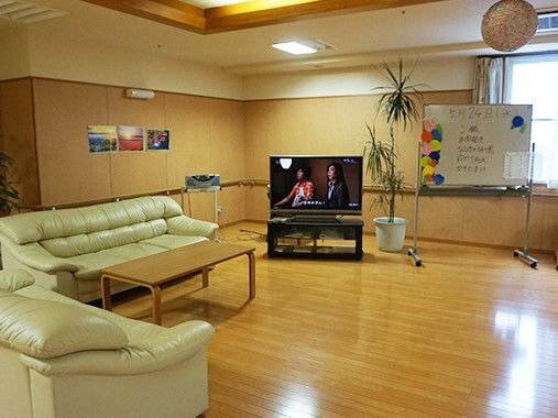 フローリングの共有スペースにはソファが置かれローテーブルやテレビもあり、カラオケが流れている。