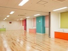 フローリングの広々としたスペース。壁はとてもカラフルで、洗面所もついている。
