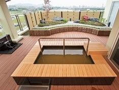 中央に手すりが付けられた足湯スペース。小さな和風庭園もある。