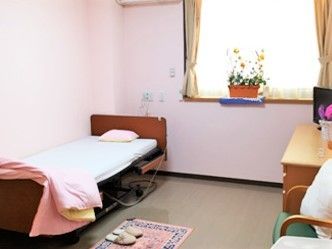 入居者の持ち物がたくさん持ち込まれた個性的な部屋。ベッドサイドには緊急通報装置がある。