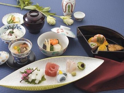 刺身や煮物、茶碗蒸しにご飯もの、漬物などが美しい器に盛られた本格的な和風のコース。猪口と徳利も置かれている。