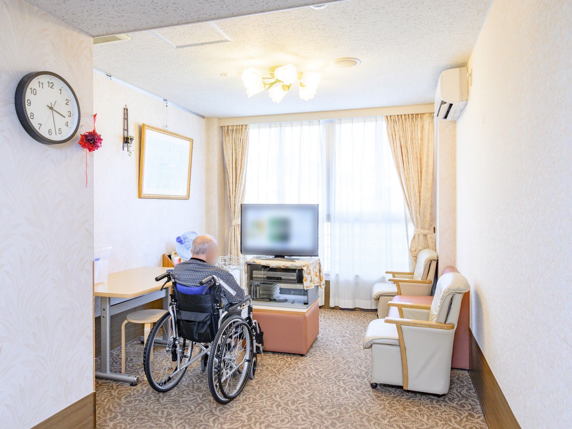 テレビで映像を見ている車椅子の男性