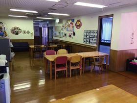 食堂にはダイニングテーブルが並び、壁には作品などが飾られている。日当たり良好。