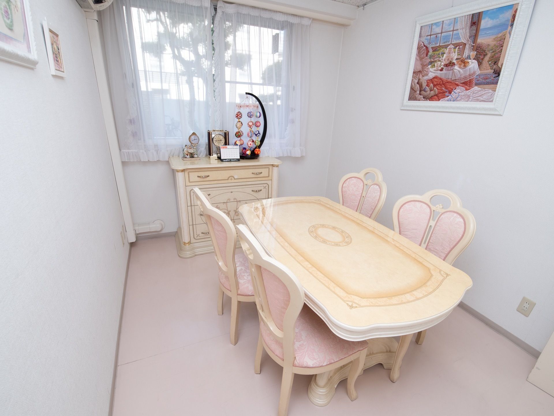 かわいい椅子やテーブル、調度品が置かれた談話室である。壁には白色の額縁に入った洋風の絵画が飾られている。