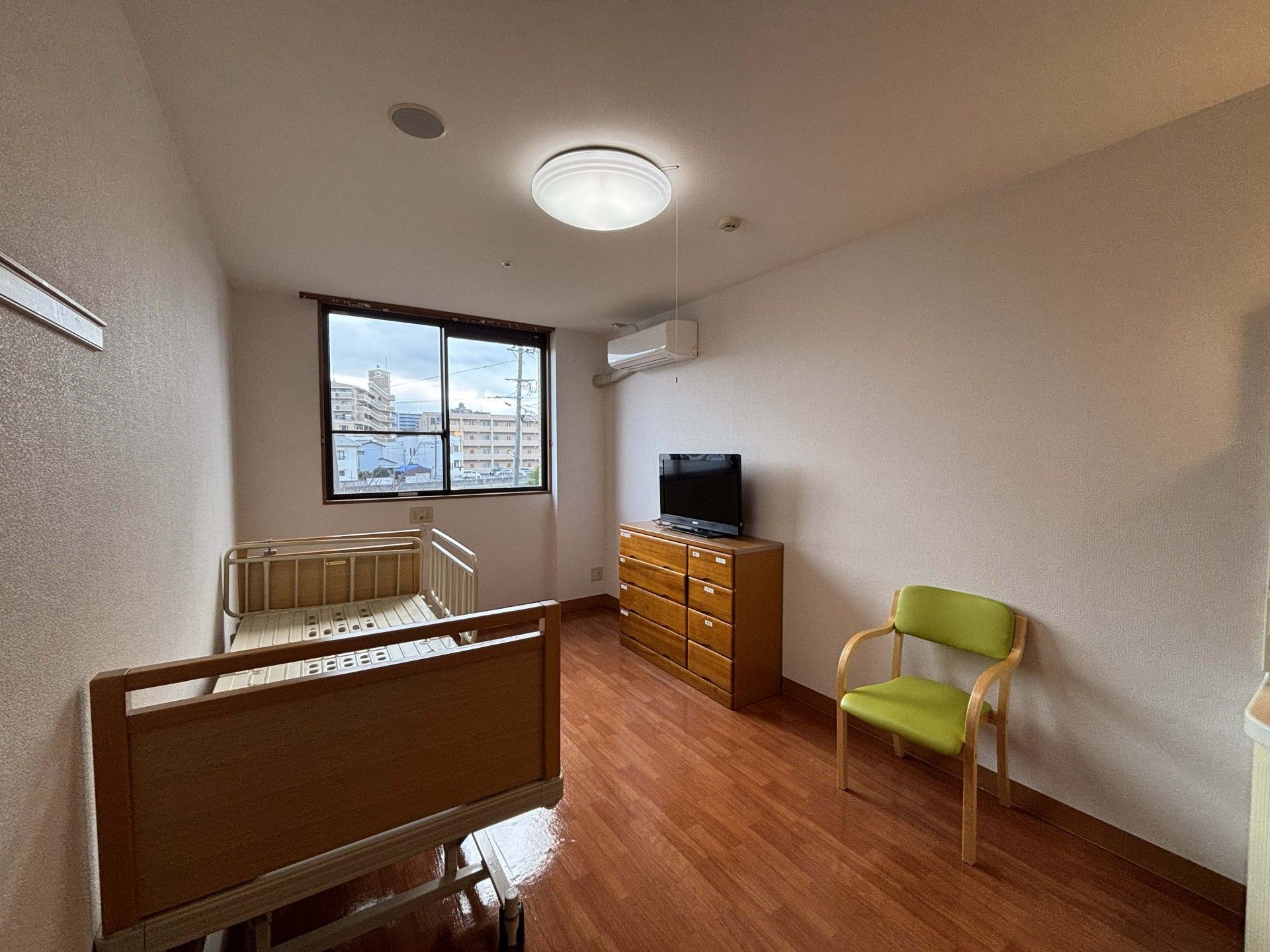 窓際のベッドと椅子の部屋