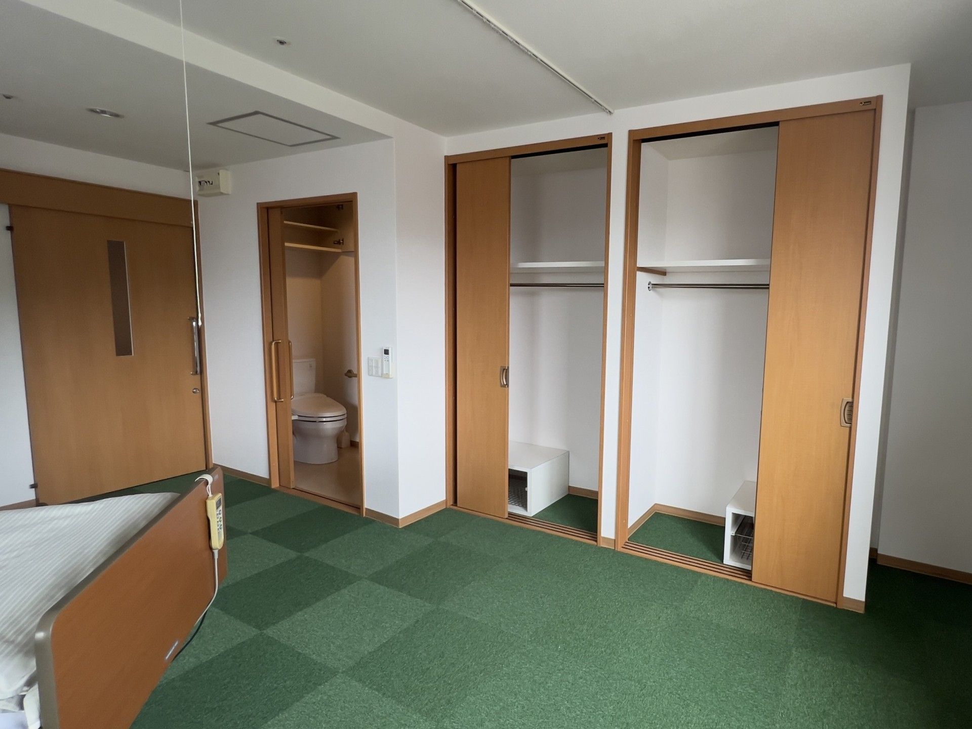 緑色の絨毯の個室部屋