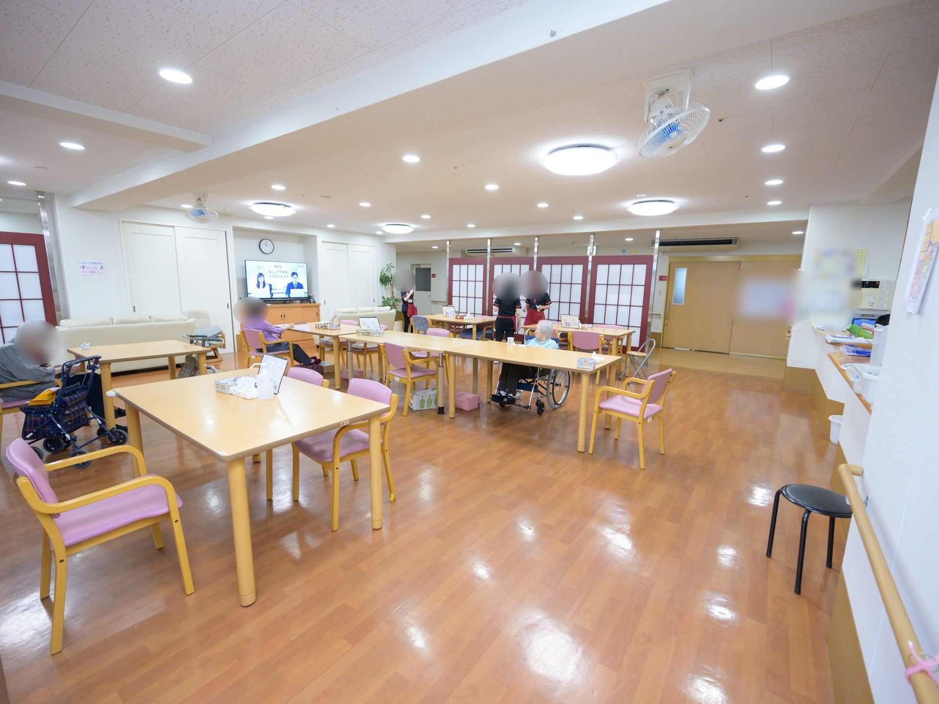 白色の壁に、木風の床で構成された談話室である。1つの机と4脚から8脚の椅子が1セットとして設置されている。