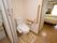 居室のベッドから近い場所に、トイレが設置されている。奥には洗面台や浴室が配置され、水廻りの設備が集約されている。