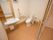 スライドドアを開けると、木目調の落ち着いた内装でまとめられたトイレがある。個室内には洗面台も設置され、便利な収納棚も備え付けられている。