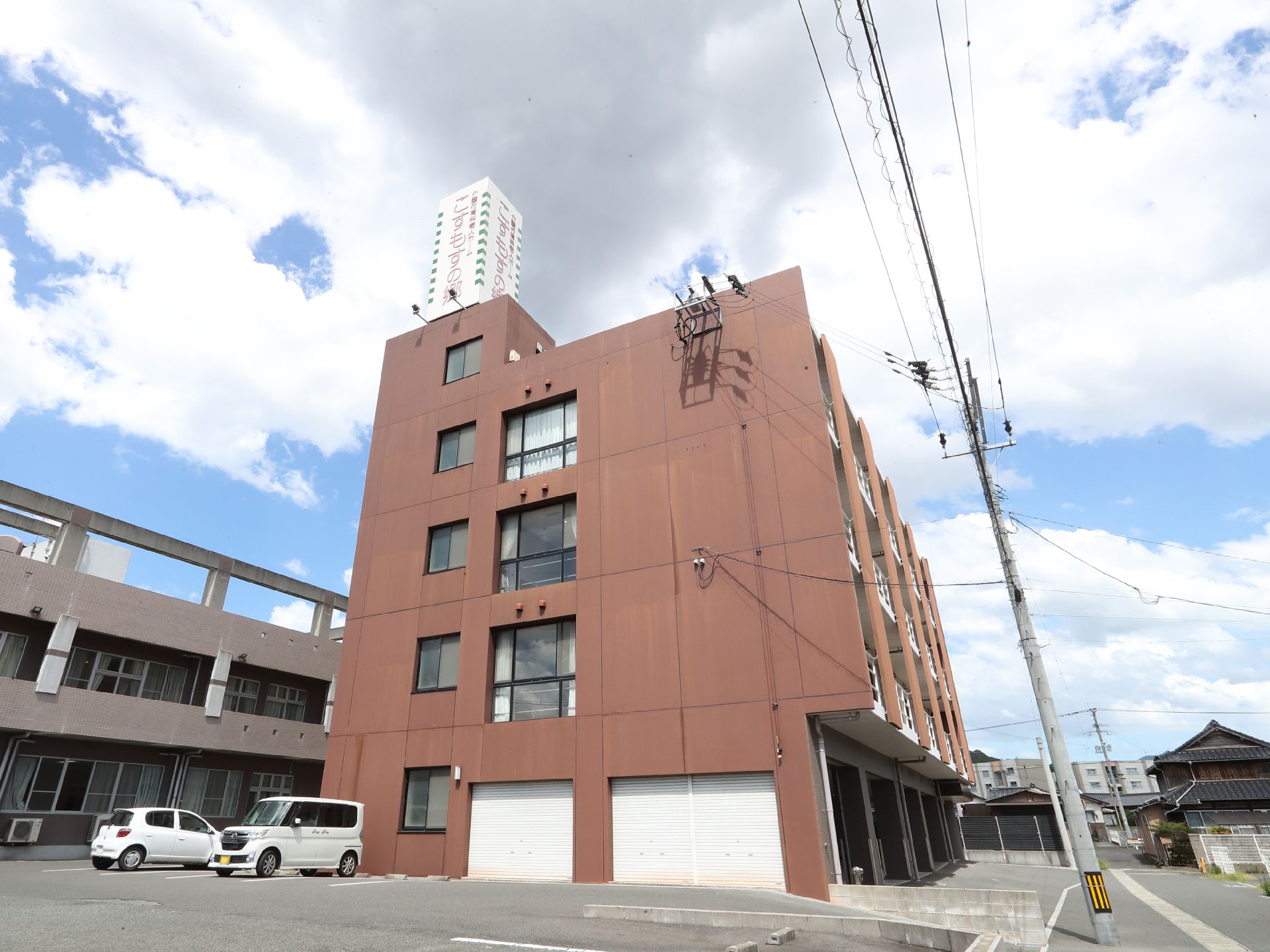 アスファルトに隣接している茶色い外観で５階建ての建物