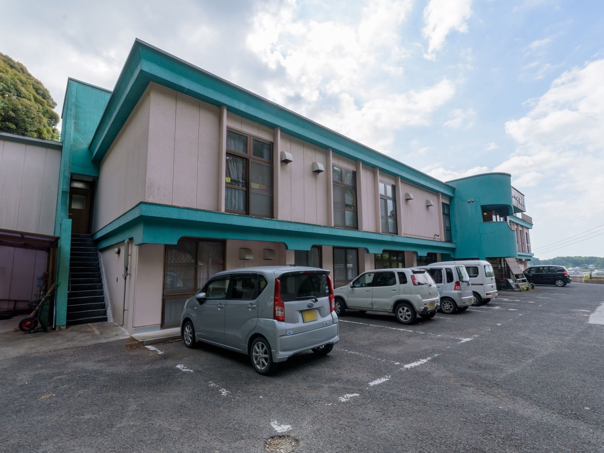 敷地内に駐車場があり、建物のすぐ前に車が５台停められている。玄関の近くには、車椅子専用のスペースも用意されている。